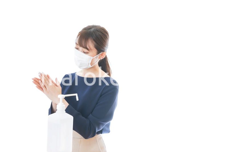 手のアルコール消毒をする若い女性