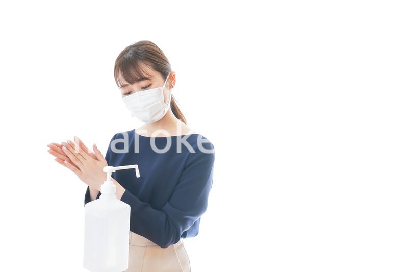 手のアルコール消毒をする若い女性