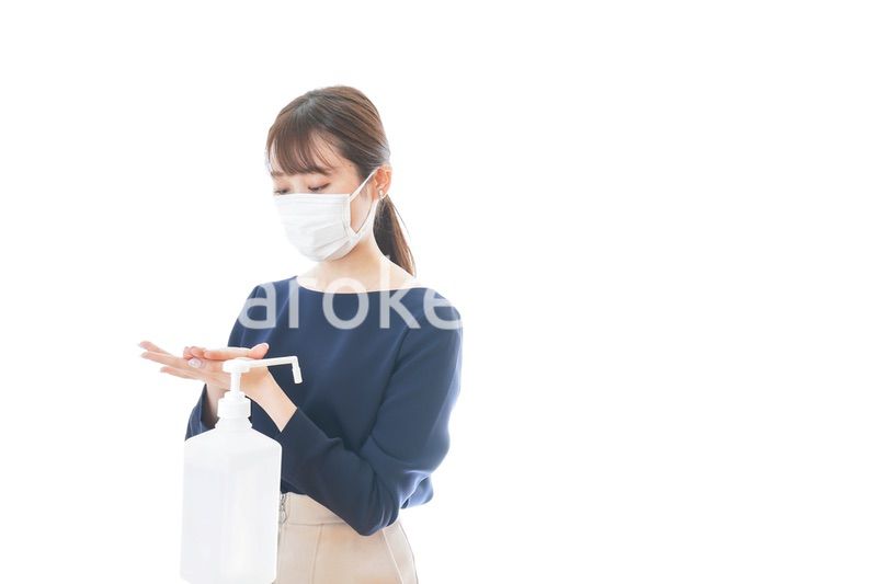 手のアルコール消毒をする若い女性