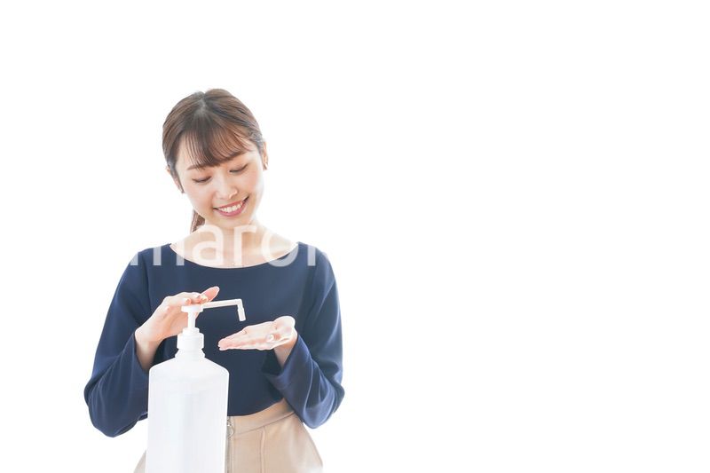 手のアルコール消毒をする若い女性