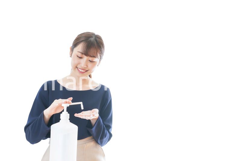 手のアルコール消毒をする若い女性