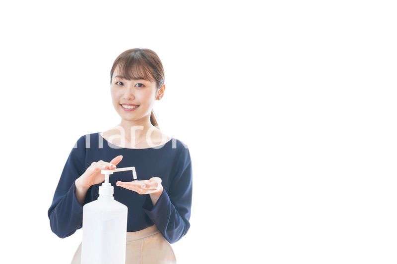 手のアルコール消毒をする若い女性