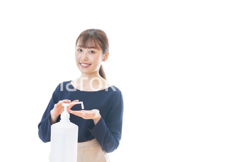 手のアルコール消毒をする若い女性