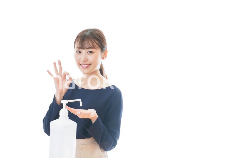 OKサインをしながらアルコール消毒をする若い女性