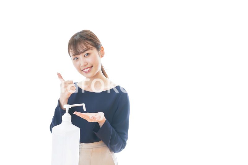 OKサインをしながらアルコール消毒をする若い女性