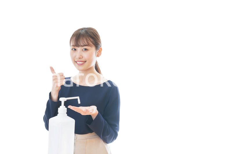 OKサインをしながらアルコール消毒をする若い女性