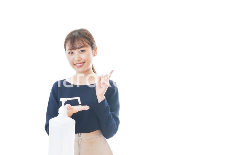OKサインをしながらアルコール消毒をする若い女性