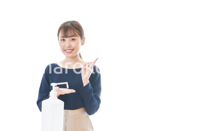 OKサインをしながらアルコール消毒をする若い女性