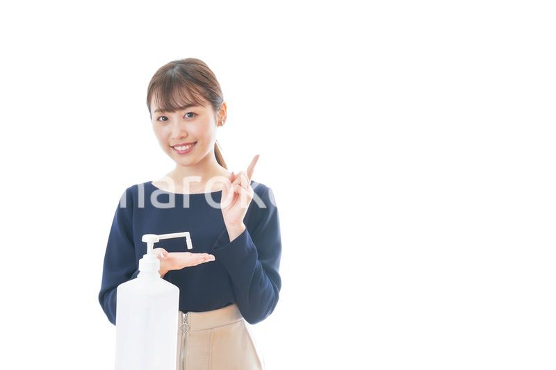 OKサインをしながらアルコール消毒をする若い女性