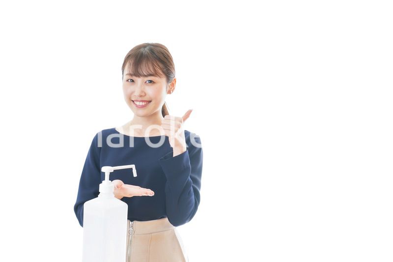 OKサインをしながらアルコール消毒をする若い女性
