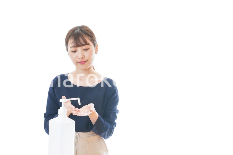 手のアルコール消毒をする若い女性