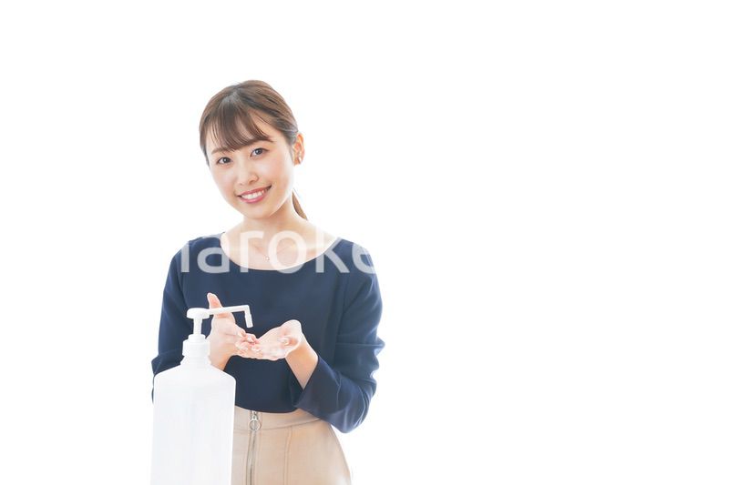 手のアルコール消毒をする若い女性