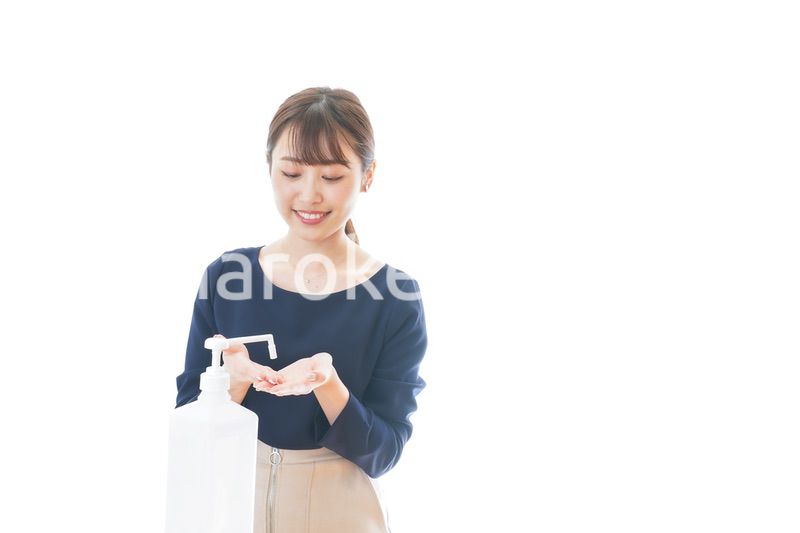 手のアルコール消毒をする若い女性