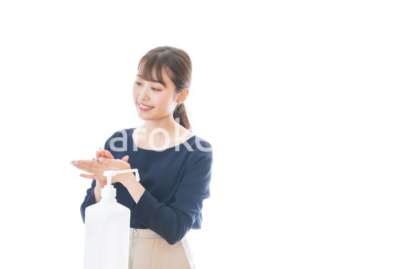 手のアルコール消毒をする若い女性