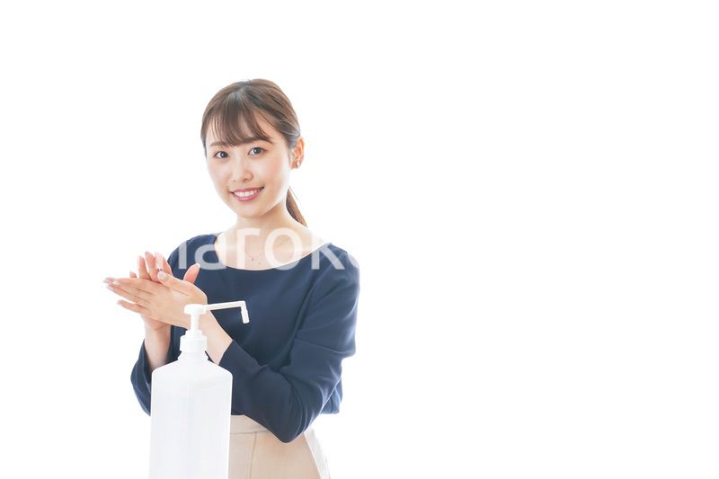 手のアルコール消毒をする若い女性