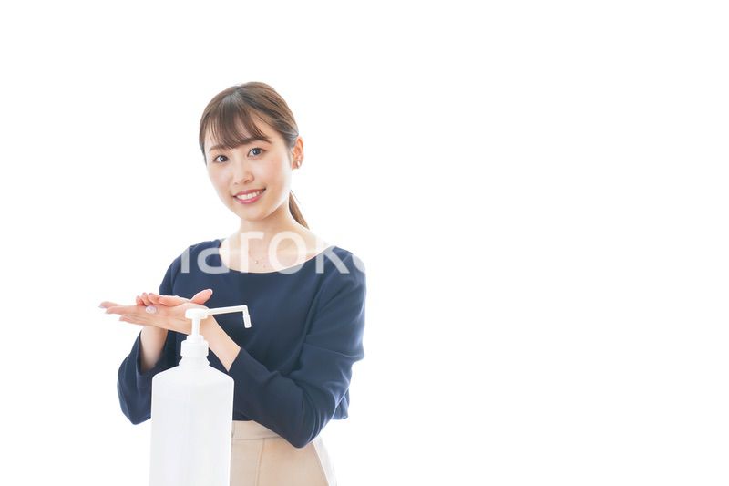 手のアルコール消毒をする若い女性