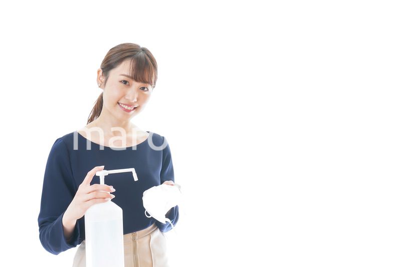 マスクをアルコール消毒する若い女性