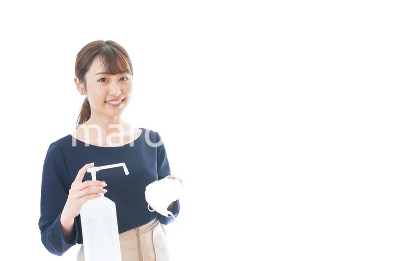 マスクをアルコール消毒する若い女性