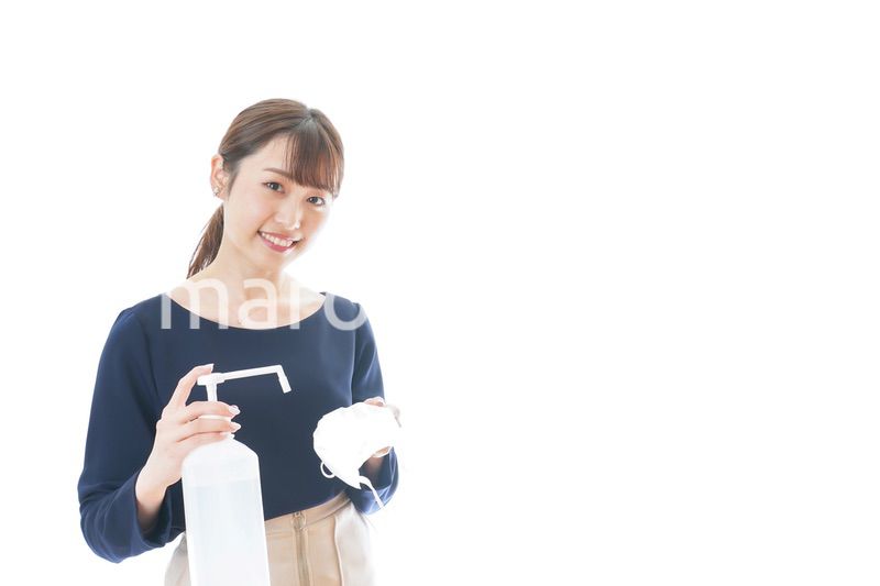 マスクをアルコール消毒する若い女性
