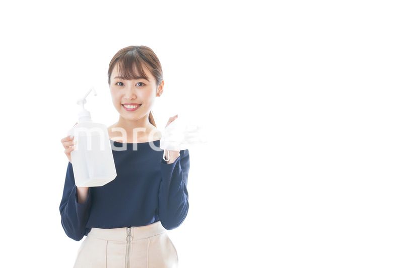 マスクとアルコール消毒液を持つ若い女性