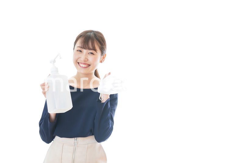 マスクとアルコール消毒液を持つ若い女性