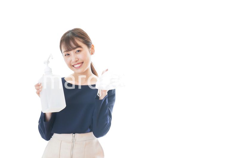 マスクとアルコール消毒液を持つ若い女性