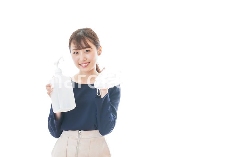 マスクとアルコール消毒液を持つ若い女性