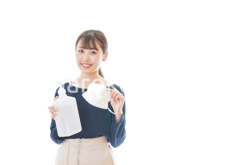 マスクとアルコール消毒液を持つ若い女性