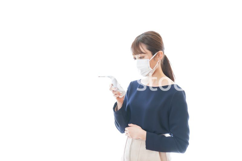 体温の測定をする若いビジネスウーマン
