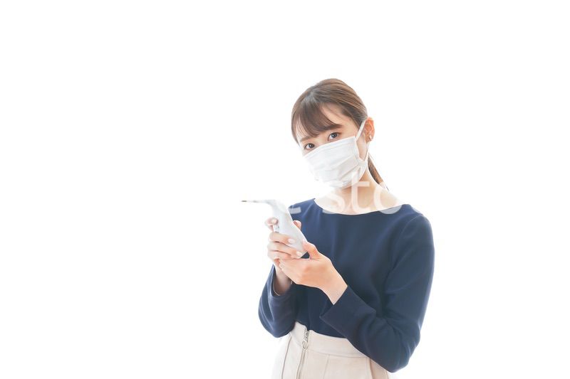 体温の測定をする若いビジネスウーマン