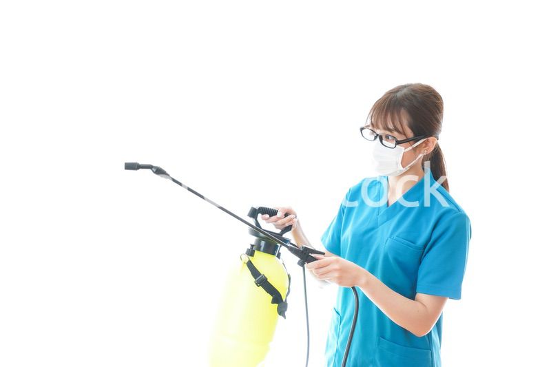 消毒液の噴霧をする医療従事者