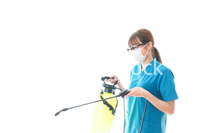 消毒液の噴霧をする医療従事者