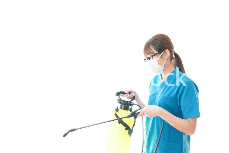 消毒液の噴霧をする医療従事者