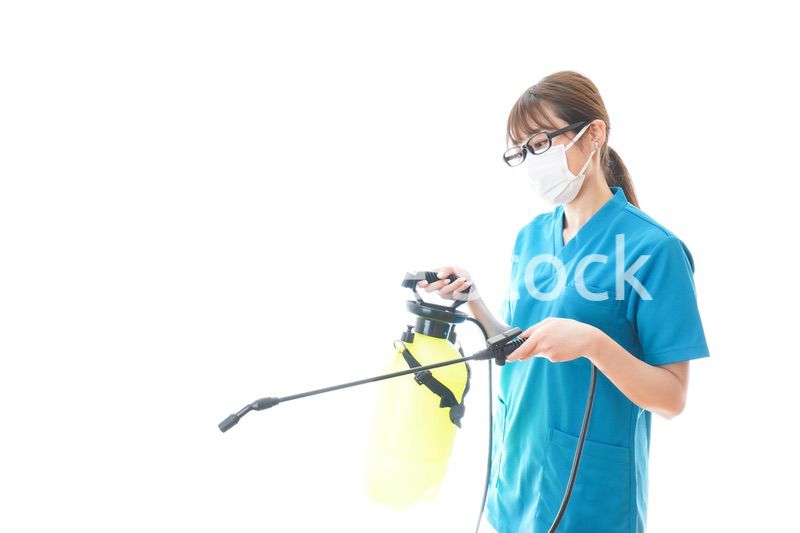 消毒液の噴霧をする医療従事者