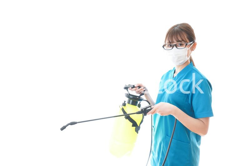 消毒液の噴霧をする医療従事者