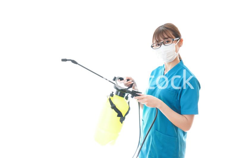 消毒液の噴霧をする医療従事者