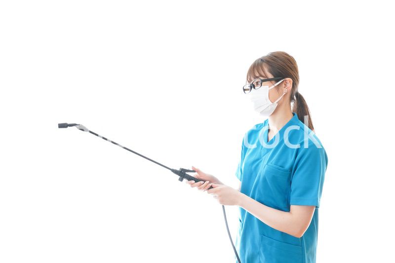 消毒液の噴霧をする医療従事者