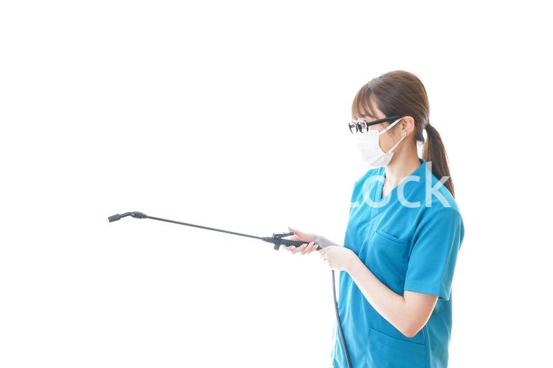 消毒液の噴霧をする医療従事者