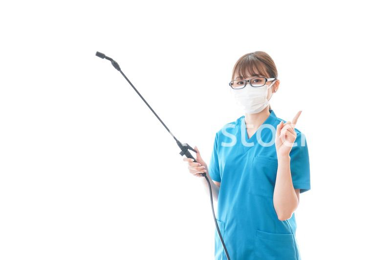 消毒液を持ちアドバイスをする医療従事者