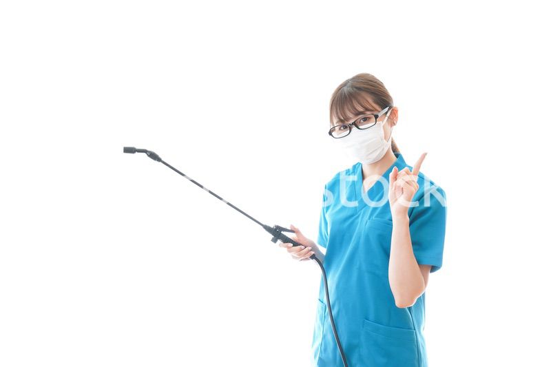 消毒液を持ちアドバイスをする医療従事者