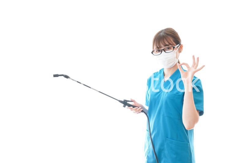 消毒液を持ちアドバイスをする医療従事者