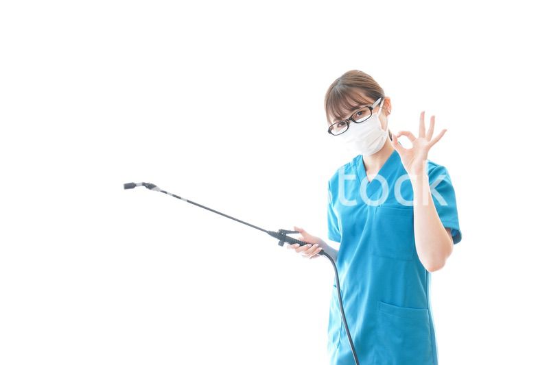 消毒液を持ちアドバイスをする医療従事者