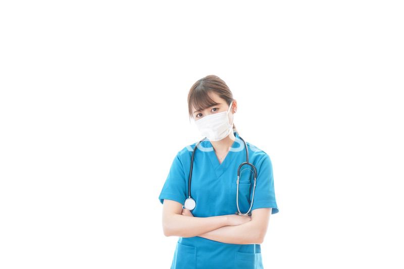 マスクを装着して悩む医師