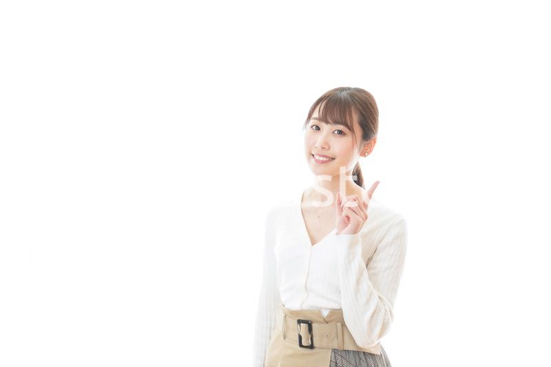 笑顔で指をさす若い女性
