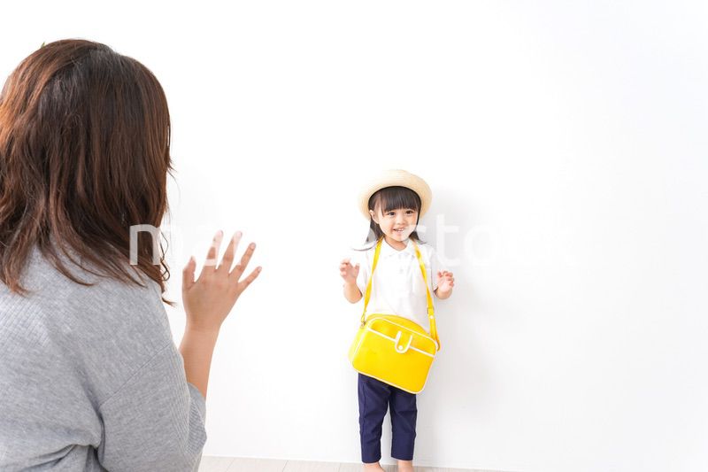 幼稚園に行く子どもと見送るお母さん