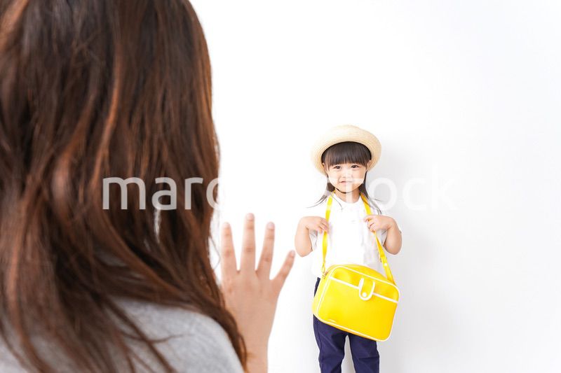 幼稚園に行く子どもと見送るお母さん