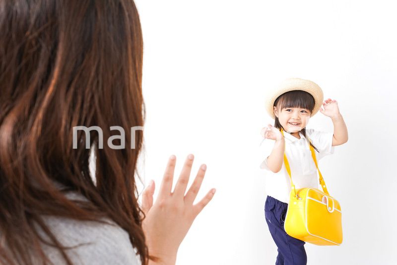 幼稚園に行く子どもと見送るお母さん