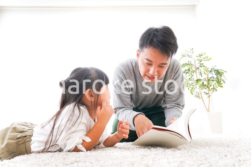 本の読み聞かせをするお父さん