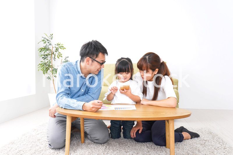 子どもに教育をする両親