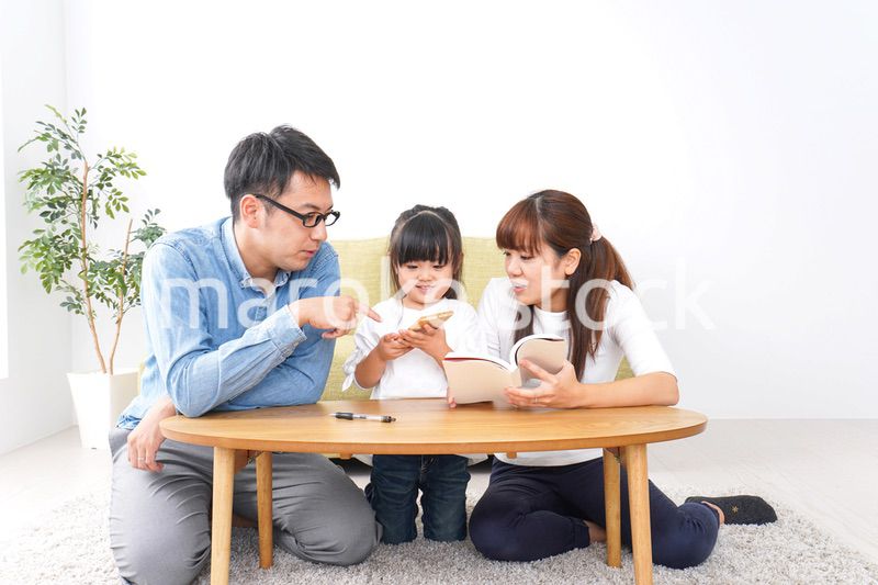子どもに教育をする両親